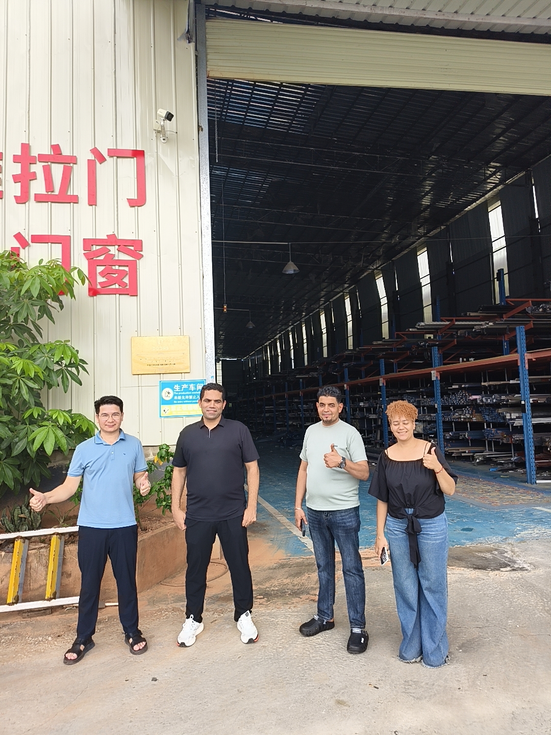 Lily et un groupe devant un atelier de fabrication en Chine